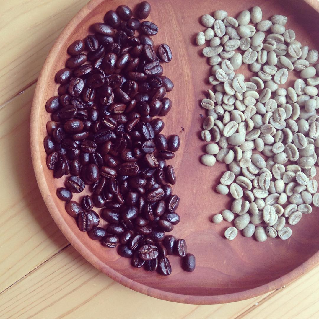 Green and roasted coffee beans side by side